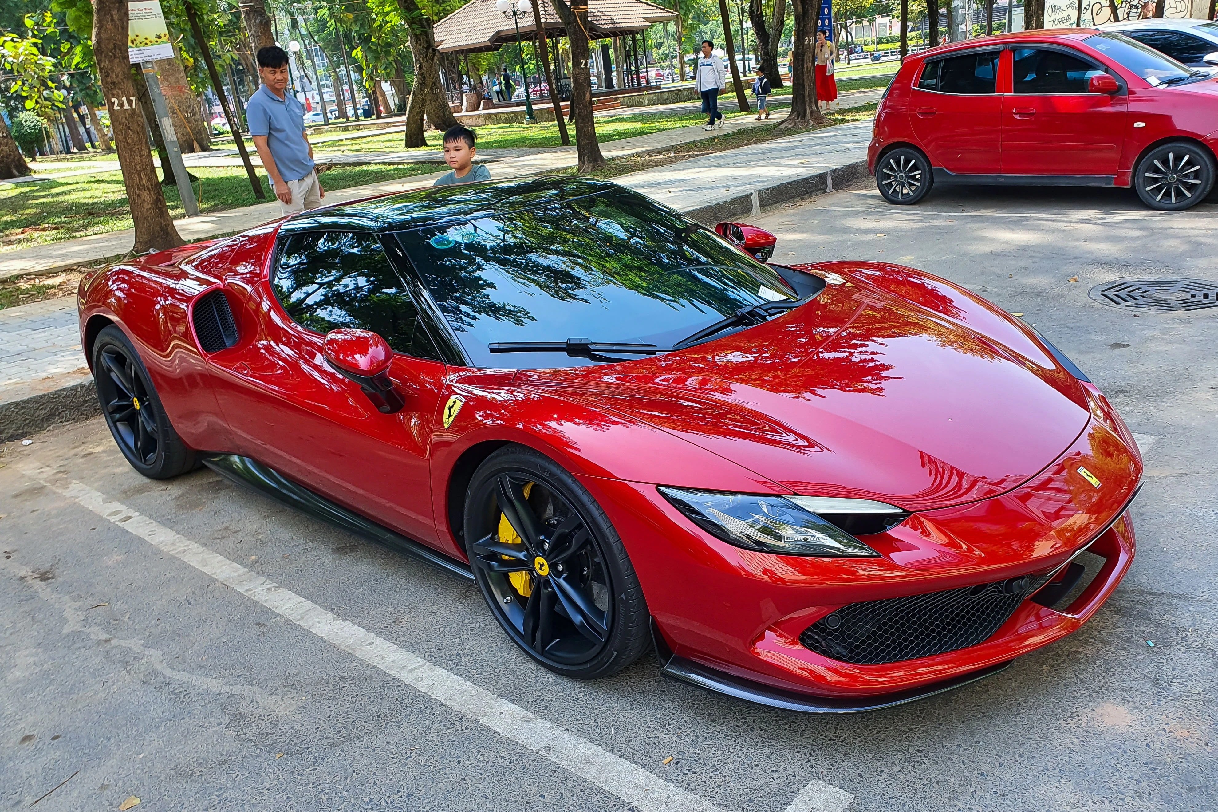 Red Ferrari 296 GTB supercar on the road.