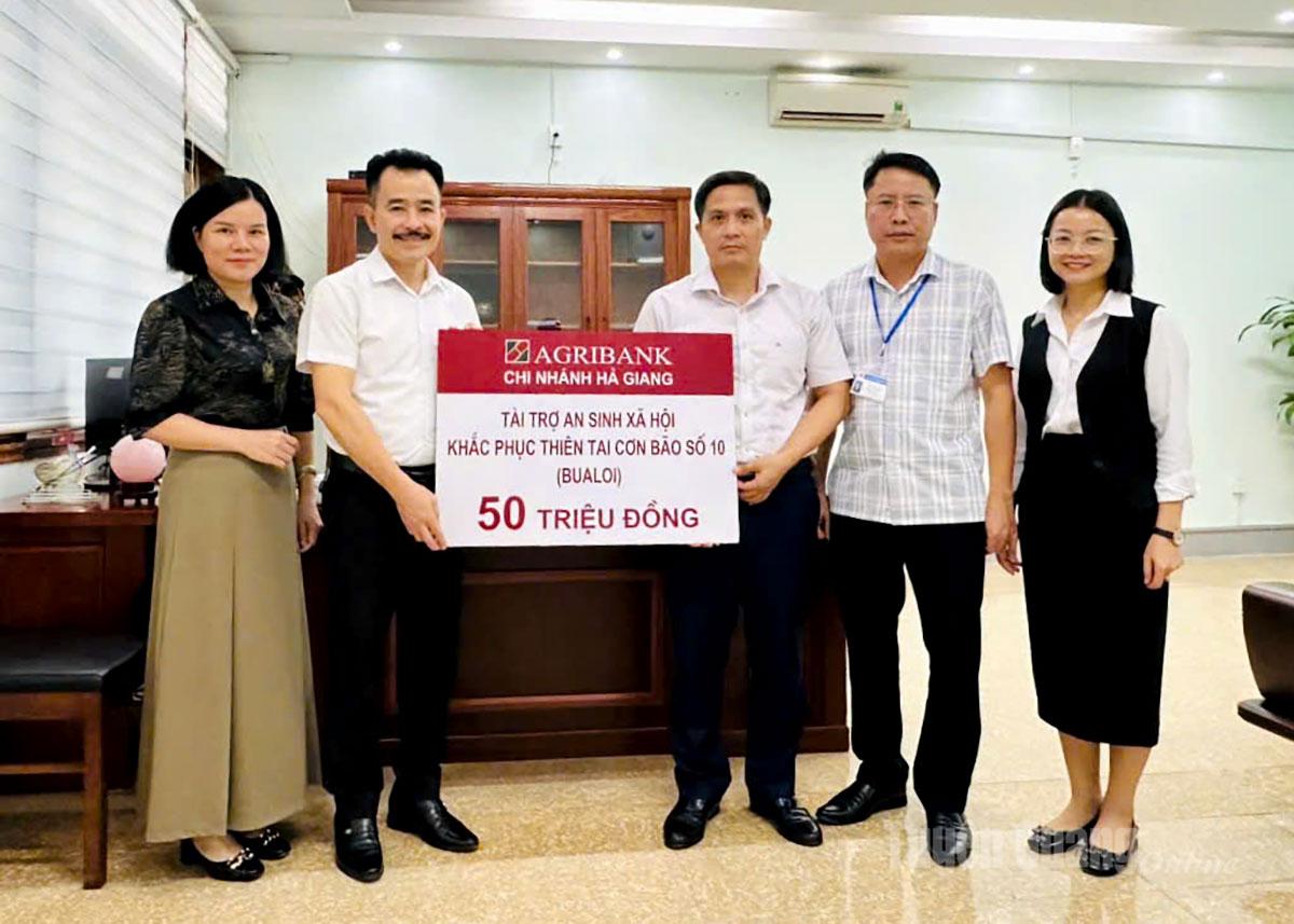 O diretor da agência do Agribank Ha Giang, Nguyen Trung Tuyen, entregou 50 milhões de VND aos líderes do bairro Ha Giang 2 para superar os danos causados ​​pelas enchentes.