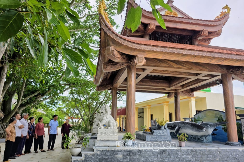 Turister lytter til historier om hvalgraven ved Cua Lan-tempelet i Dong Chau kommune.