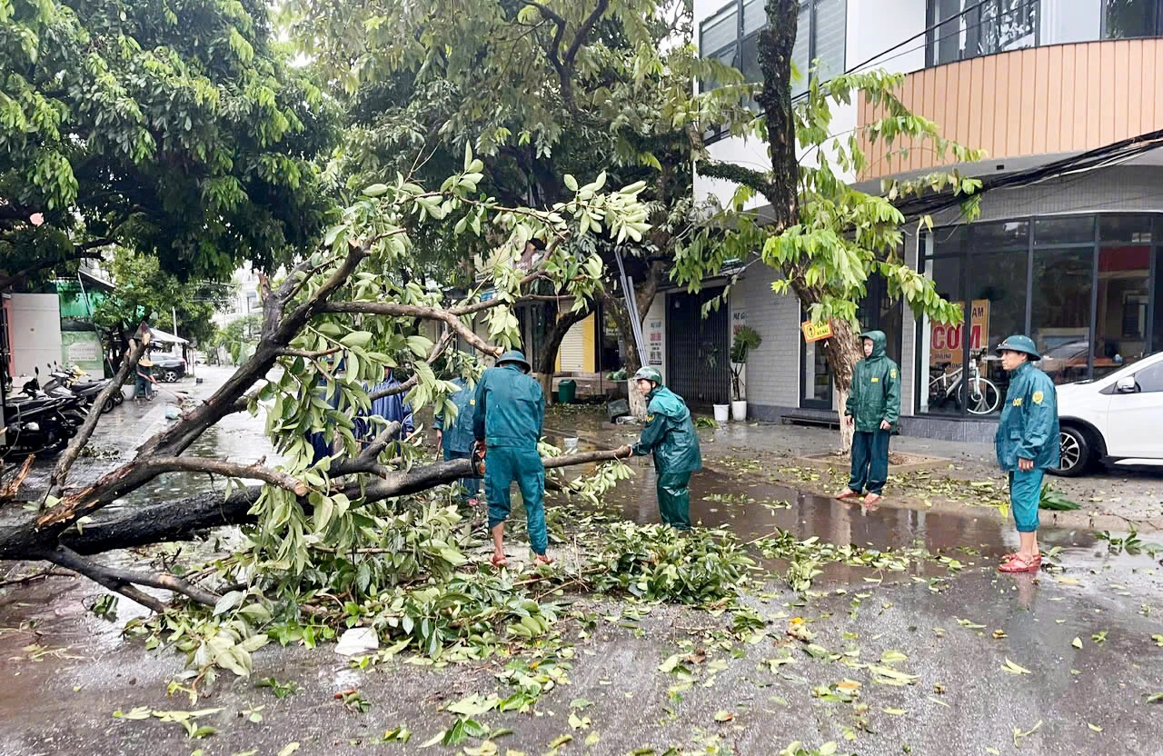 Pasukan Pengawal Sempadan Wilayah mengambil bahagian dalam membersihkan laluan trafik yang rosak akibat pokok tumbang - Foto: T.L