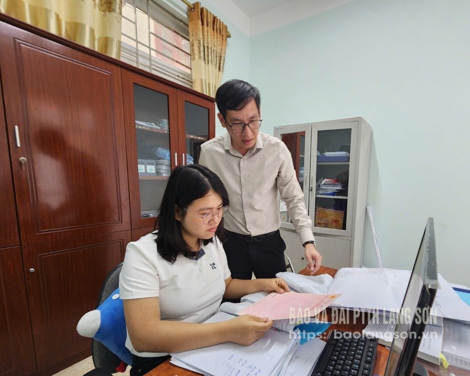 Para pemimpin Departemen Ekonomi Komune Loc Binh (kanan) memeriksa penggunaan formulir