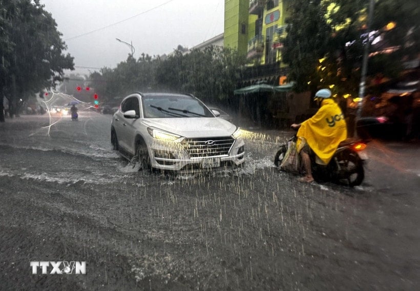 Menschen und Fahrzeuge haben auf den überfluteten Straßen der Stadt Dong Hoi (Quang Tri) mit großen Schwierigkeiten zu kämpfen. (Foto: VNA)