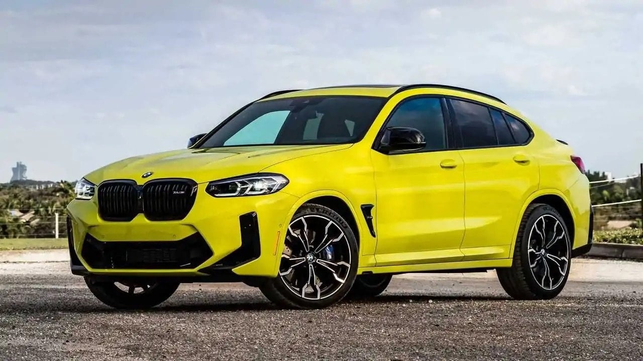 एक स्पोर्टी हरे रंग की BMW X4 M कॉम्पिटिशन आधुनिक स्थान पर खड़ी है।