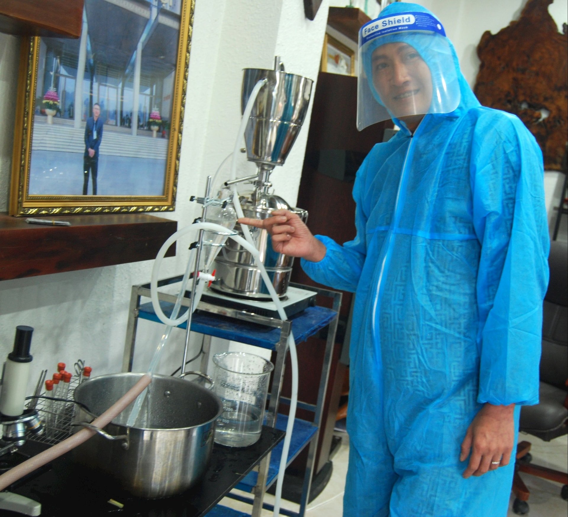 Herr Duong Ngoc Hiep med systemet som framgångsrikt extraherar den aktiva ingrediensen från röd tall.