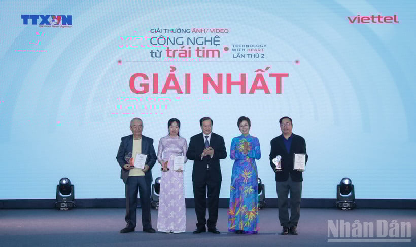 អគ្គនាយក VNA លោក Vu Viet Trang ប្រធានក្រុមប្រឹក្សាពានរង្វាន់ និងជាអនុរដ្ឋមន្ត្រីក្រសួងវប្បធម៌ កីឡា និងទេសចរណ៍ Ta Quang Dong បានប្រគល់រង្វាន់ទីមួយដល់អ្នកនិពន្ធ។ (រូបថត៖ THANH GIANG)