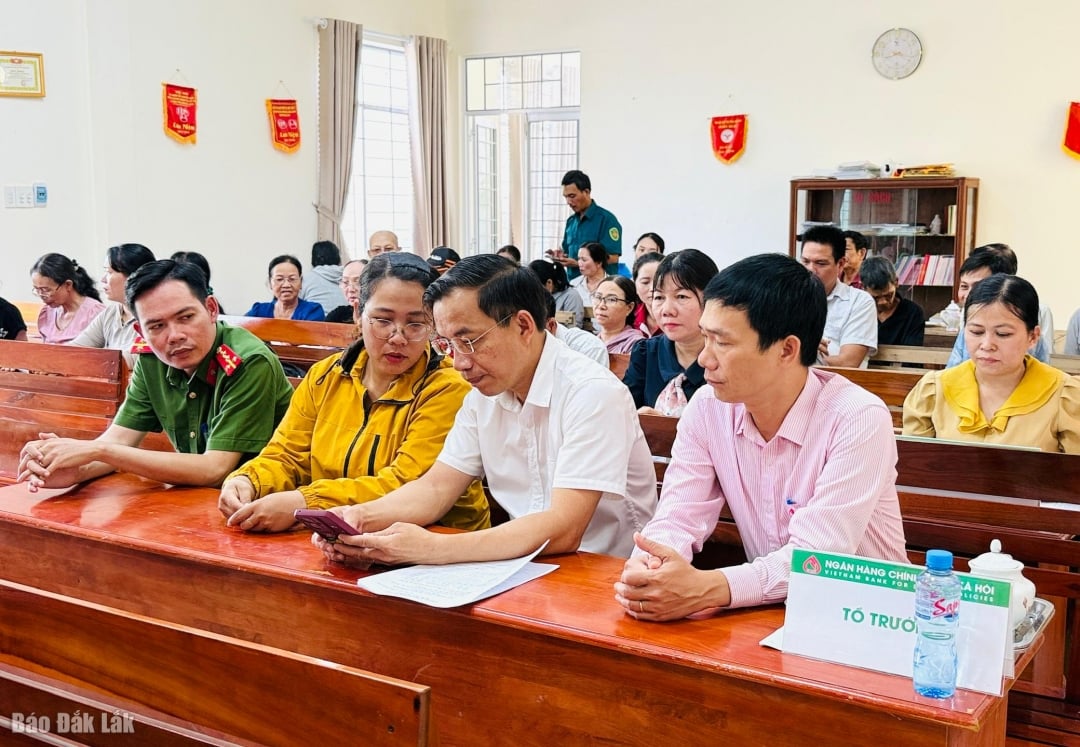 Herr Dao Thai Hoa, direktør for den provinsielle sosialpolitiske bankavdelingen, diskuterte med lederen for spare- og lånegruppen i Phu Hoa 1 kommune om å anvende digital teknologi i kapitalforvaltningsaktiviteter.