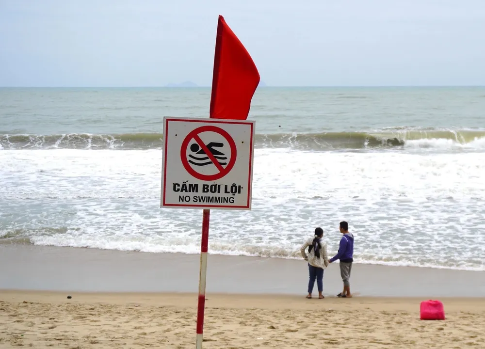 Turister varnas för att bada på Nha Trang-stranden vid farligt väder. Foto: DUC THAO