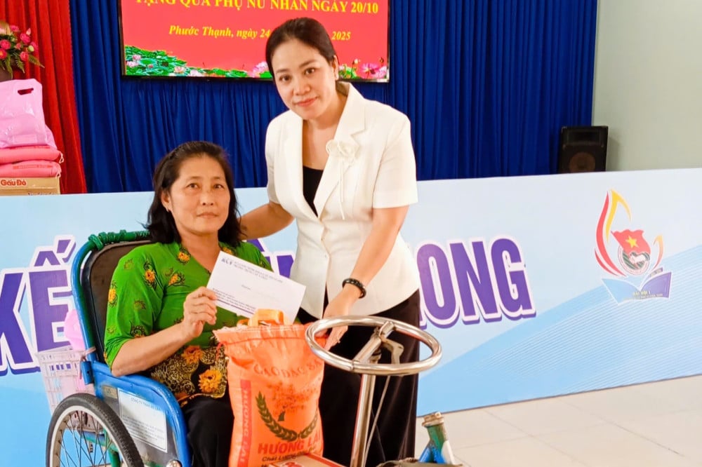 Phó Chủ tịch UBND xã Phước Thạnh Tôn Nữ Ngọc Hằng  trao quà cho phụ nữ khuyết tật