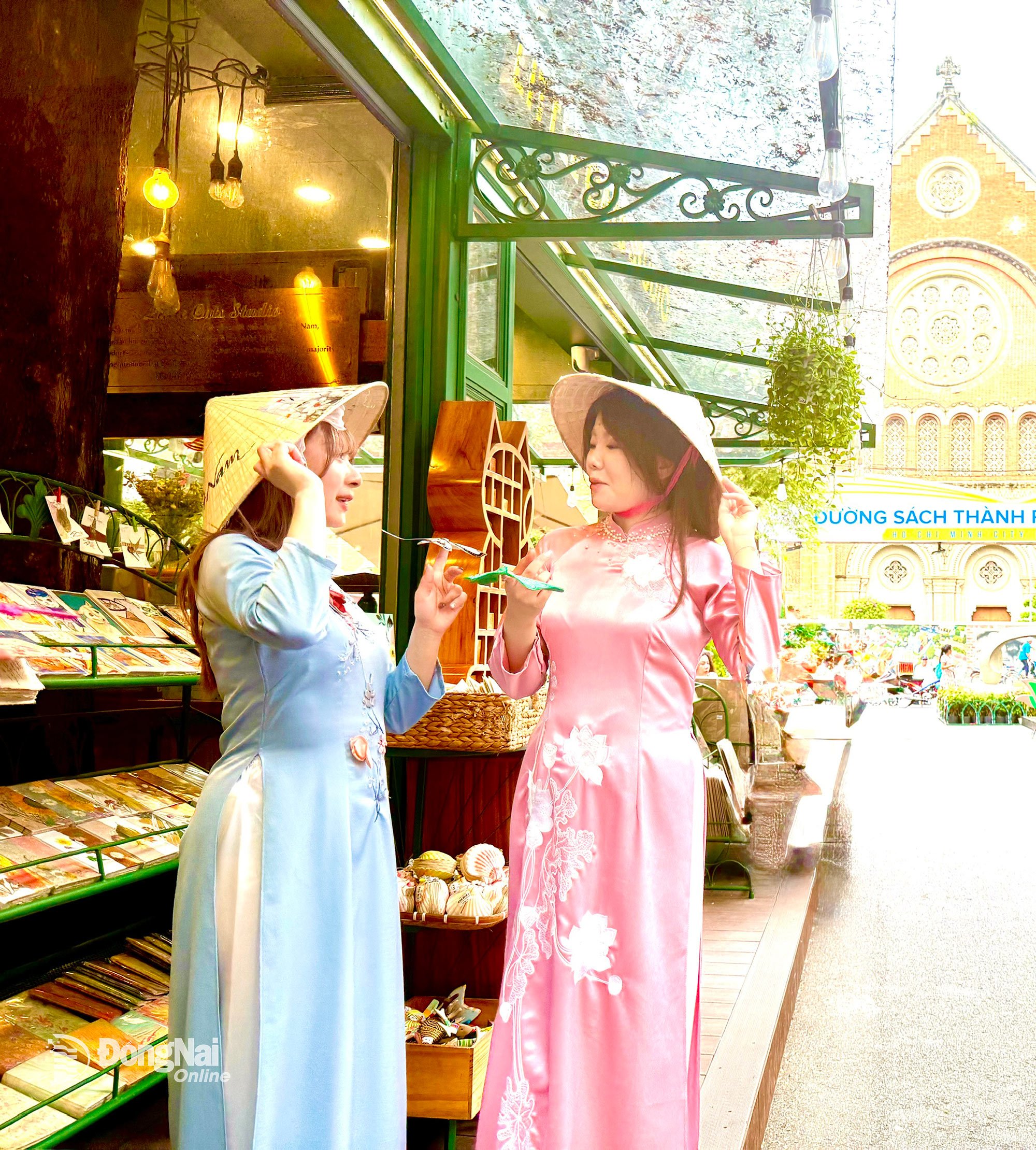 Los turistas extranjeros experimentan el uso del Ao Dai en la calle del libro de la ciudad de Ho Chi Minh.
