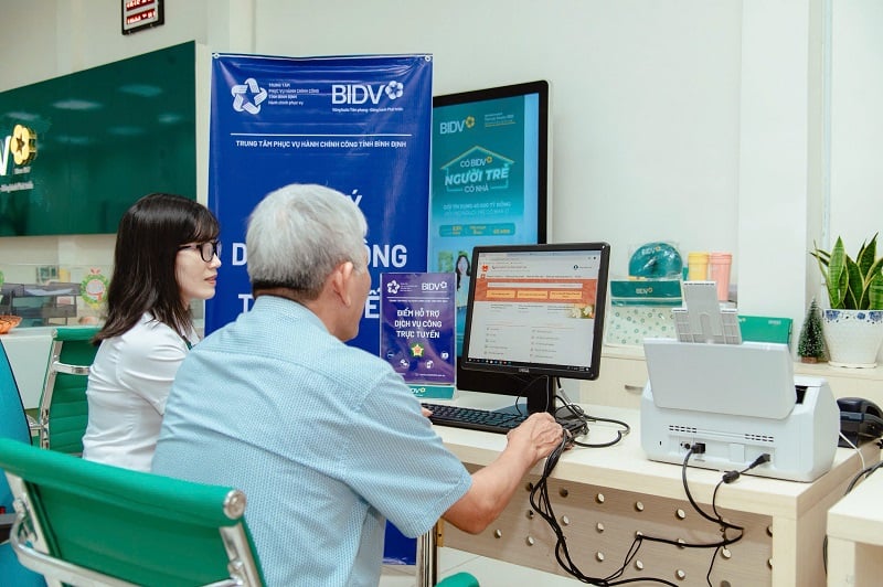 เจ้าหน้าที่ BIDV บิ่ญดิ่ญสนับสนุนผู้คนในการปฏิบัติบริการสาธารณะออนไลน์ Nhân viên BIDV Bình Định hỗ trợ người dân thực hiện dịch vụ công trực tuyến.