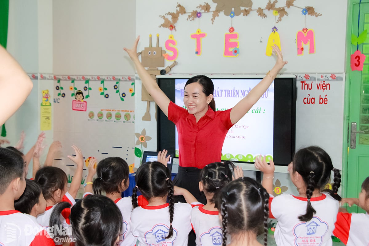 A Sra. Nguyen Thi Thu Nga orienta os alunos a se aquecerem com atividades estimulantes antes de aprenderem as letras. Foto: Nga Son