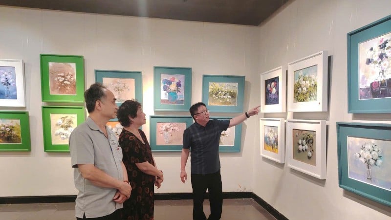 Painter Quynh Thom introduces her works to artists at the exhibition