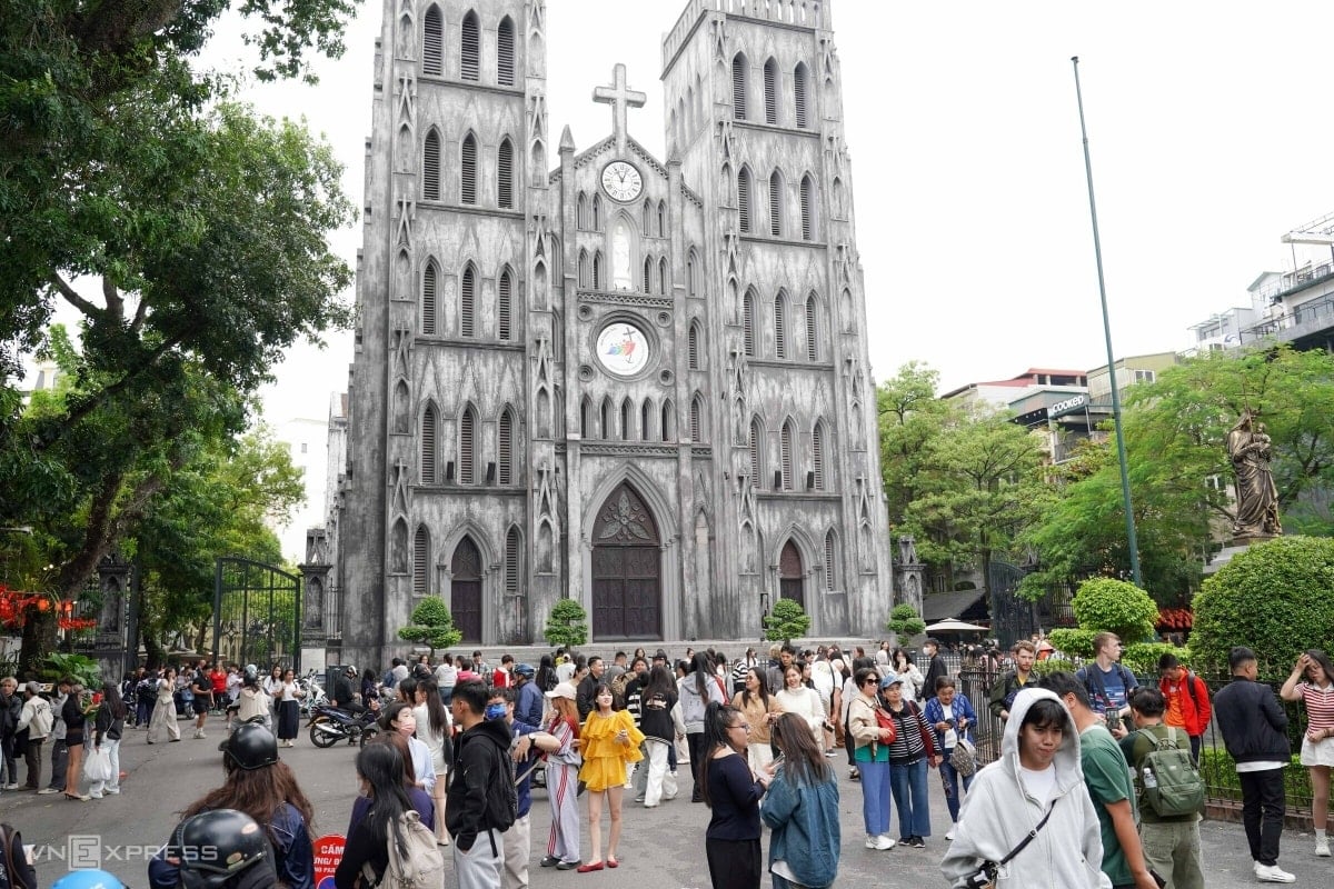 Du khách chụp ảnh check-in trước công trình kiến trúc Gothic của Nhà thờ Lớn Hà Nội.