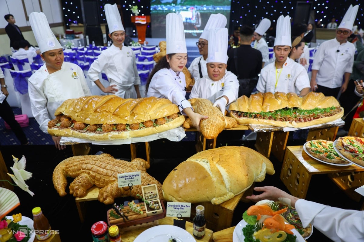O chef Bui Hoai Thanh (à direita na capa) e seus colegas apresentam um pão gigante de um metro de comprimento.