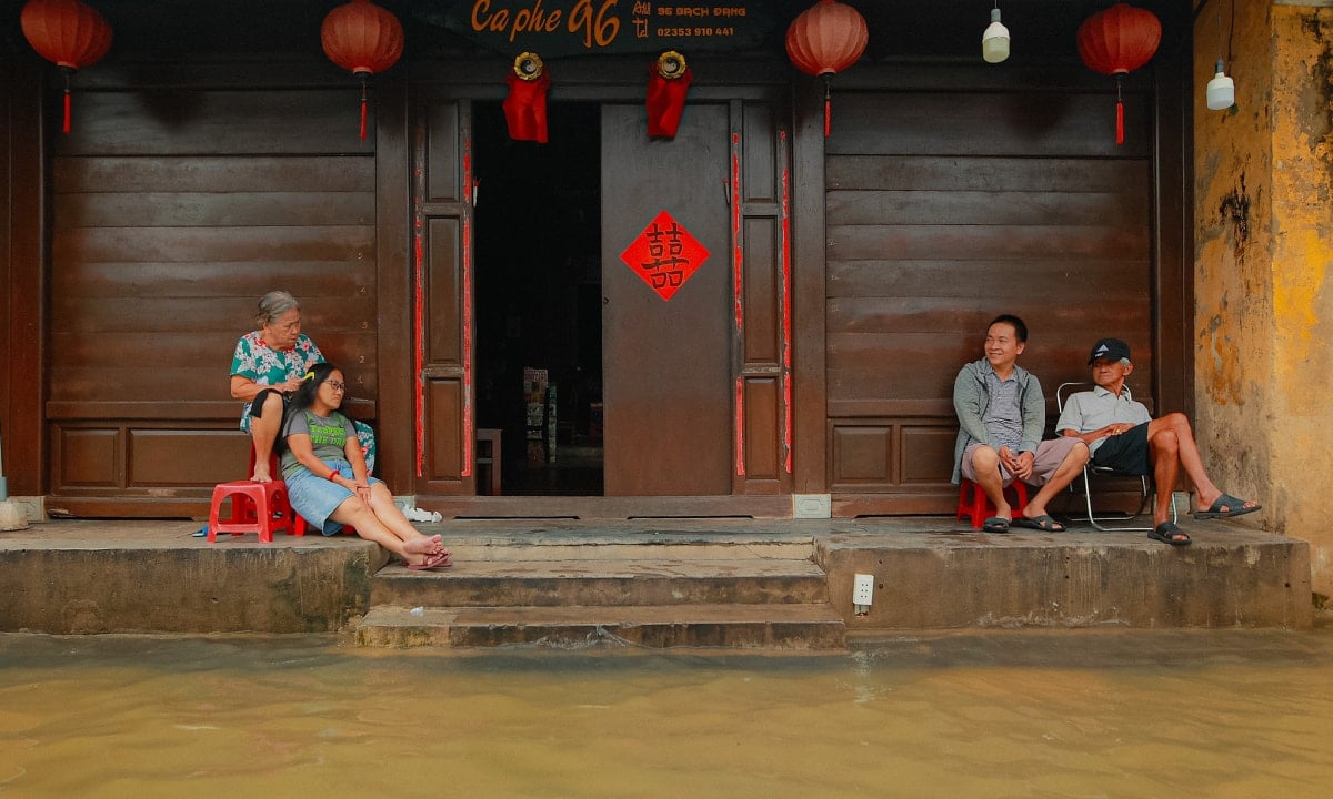 អ្នកទេសចរម្នាក់ថតរូបផ្លូវលិចទឹកក្នុងទីក្រុង Hoi An។