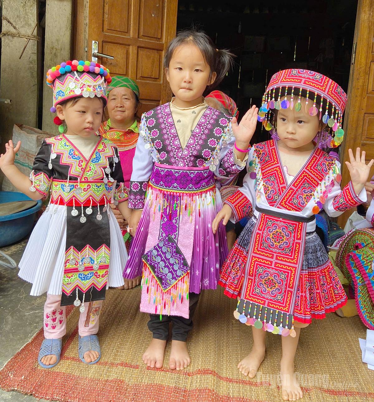 Những em bé người Mông được mẹ chuẩn bị cho bộ trang phục phục rực rỡ.