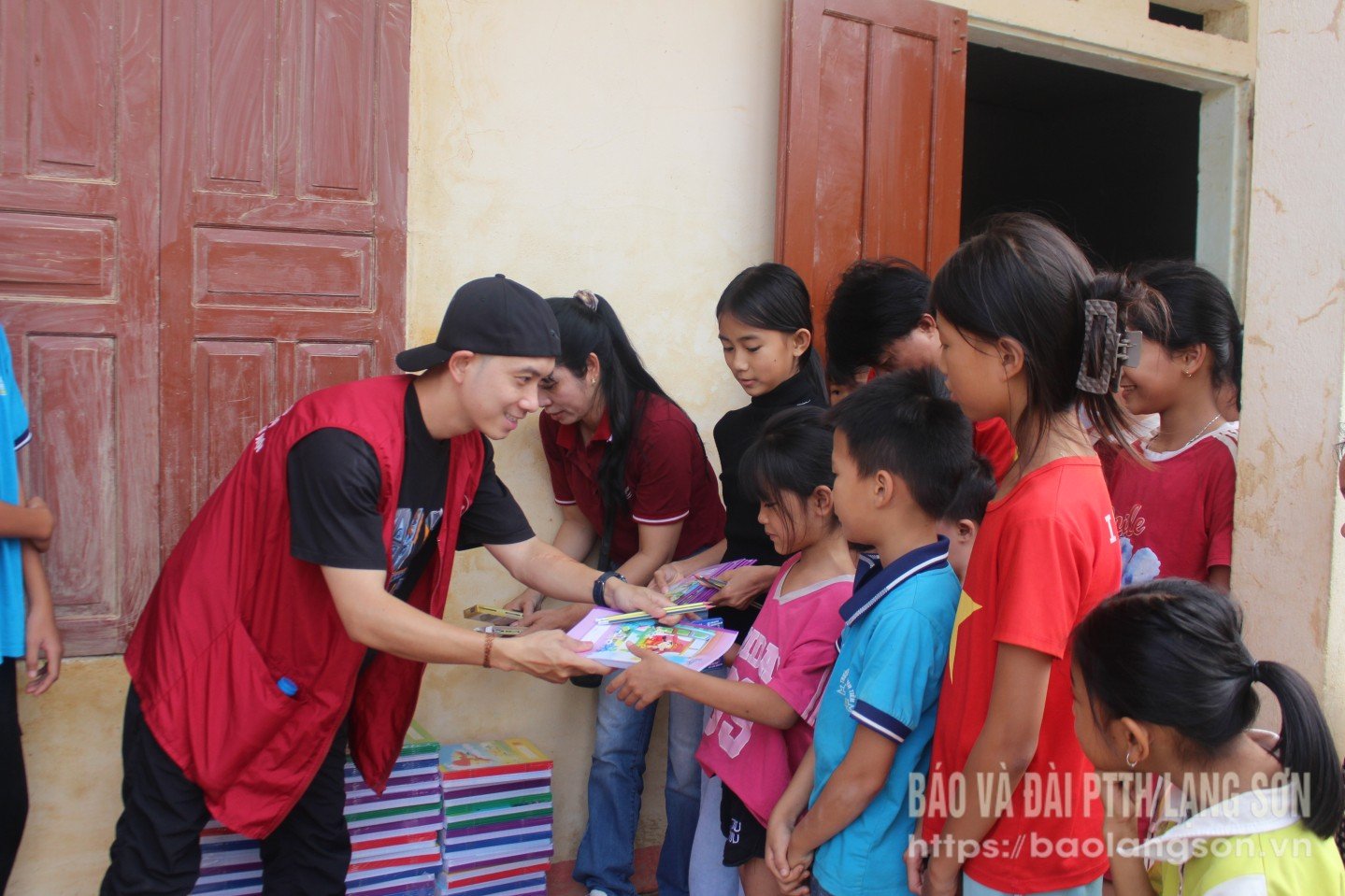 Membros do grupo de voluntários doam cadernos e canetas para alunos da região