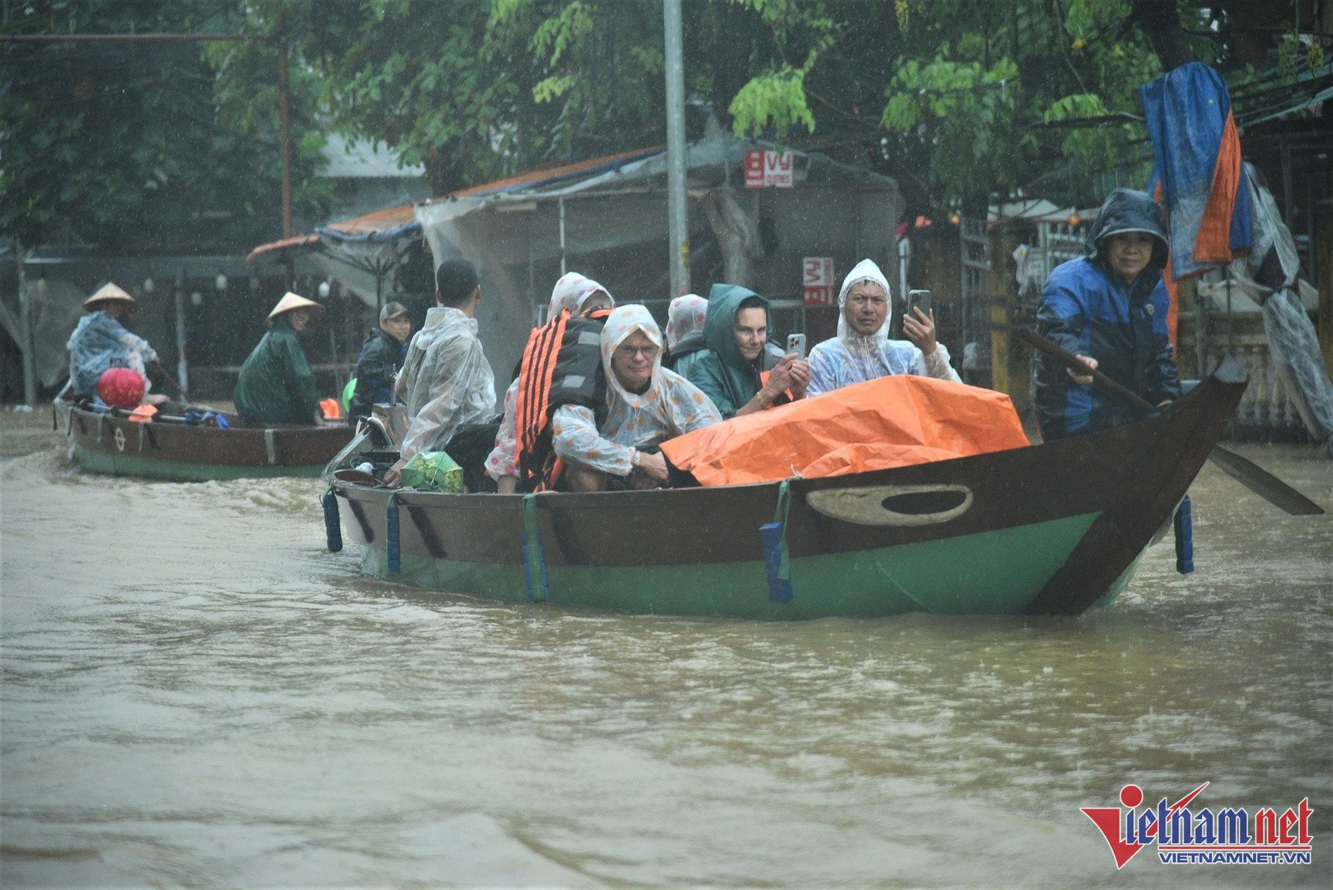 Tourists are transported by boat through flooded streets in Hoi An.