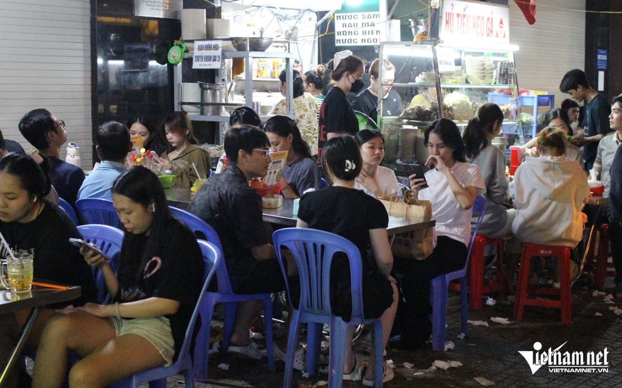 Diners filled the tables on the sidewalk of the noodle shop at midnight.
