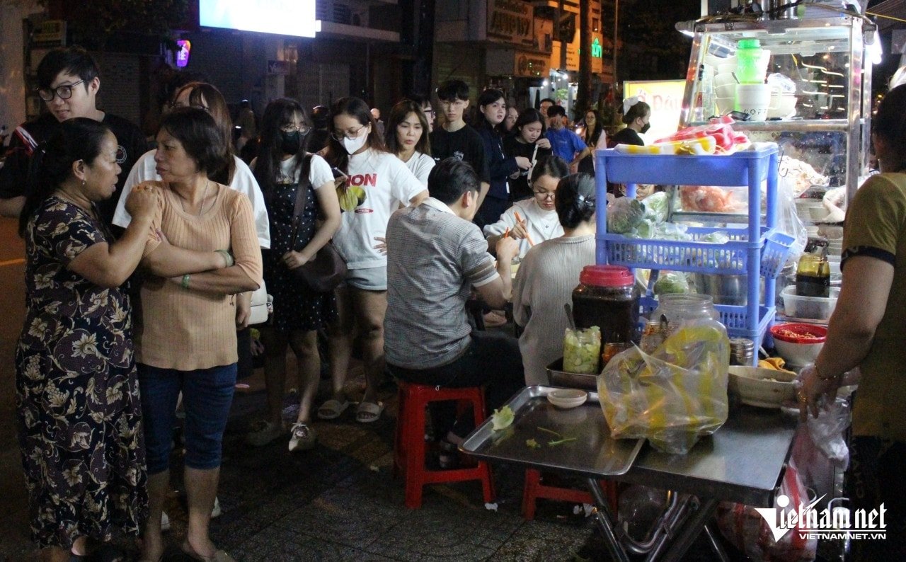 Long lines of people stood on the sidewalk waiting their turn to buy noodles.