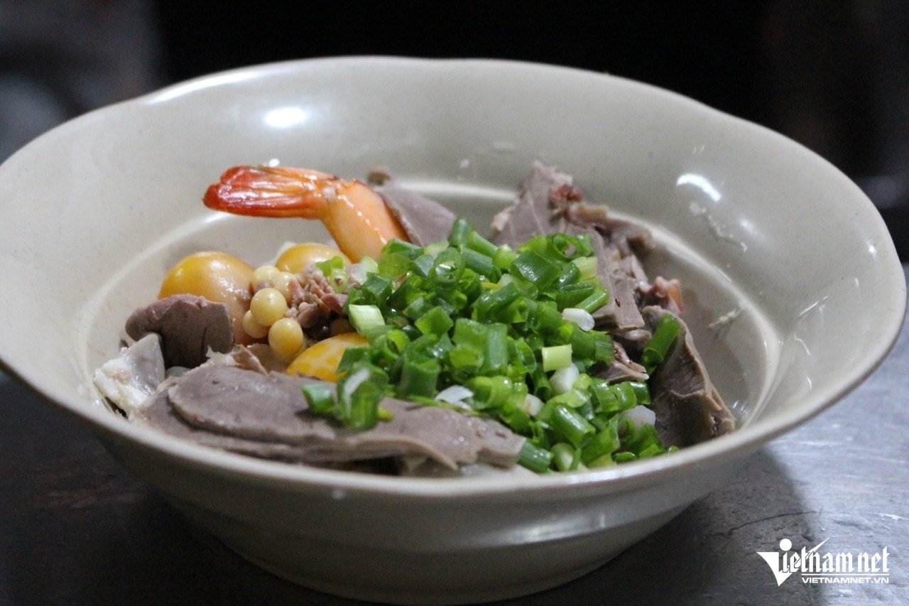 Close-up of a full bowl of noodles with clear broth and many attractive toppings.