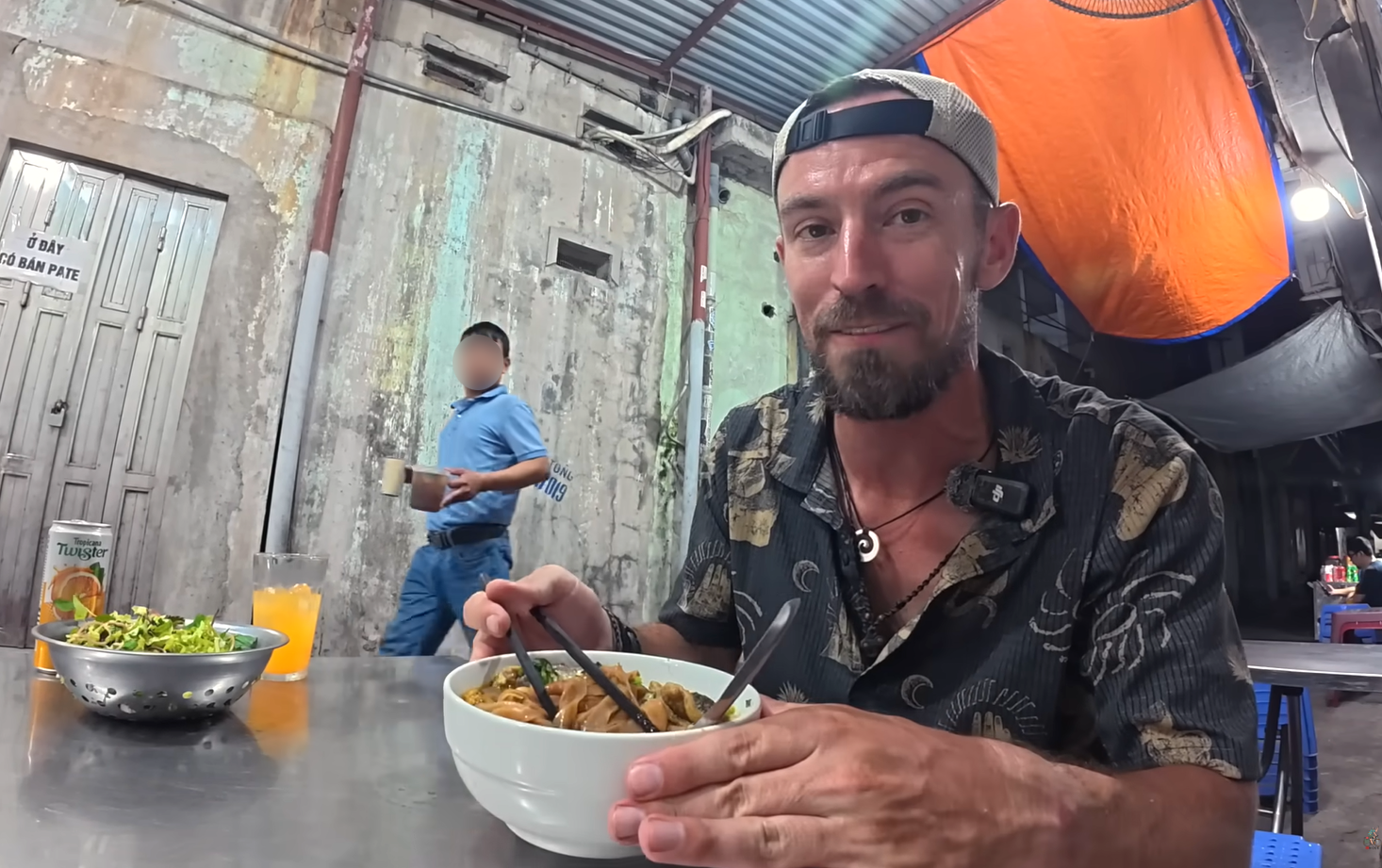 Um turista estrangeiro está saboreando sopa de macarrão com caranguejo em um restaurante na calçada em Hai Phong.