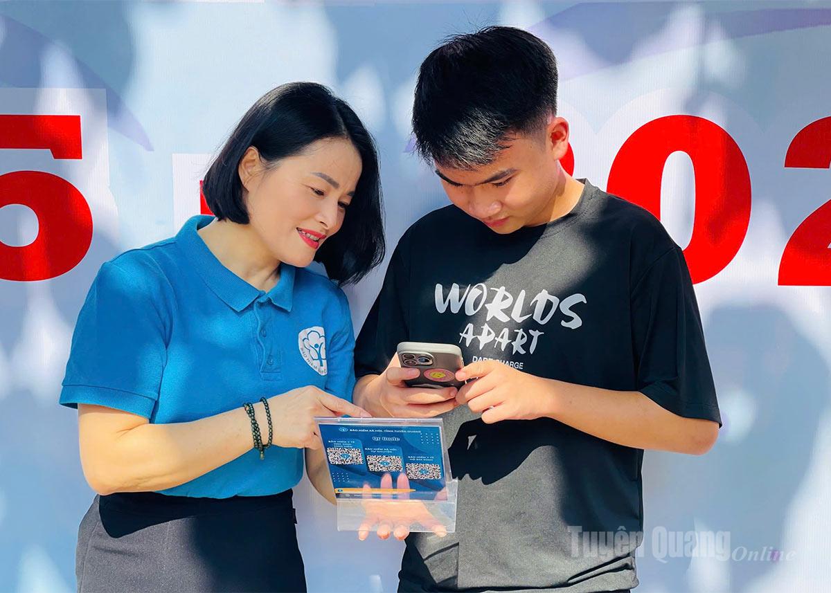 Pracownicy prowincjonalnych zakładów ubezpieczeń społecznych instruują studentów, jak skanować kody QR, aby mogli zapoznać się z informacjami na temat studenckiego ubezpieczenia zdrowotnego.