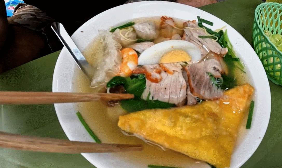 ภาพระยะใกล้ของชามบะหมี่เกี๊ยวที่เต็มไปด้วยเครื่องเคียงที่น่ารับประทาน