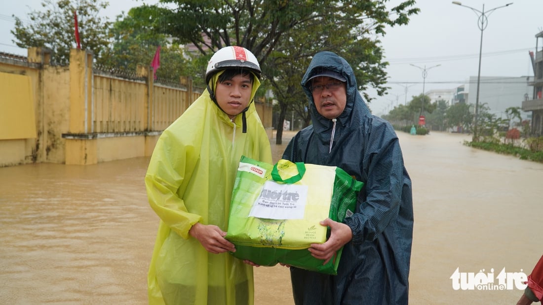 Hàng trăm suất quà cứu trợ của báo Tuổi Trẻ băng nước lũ đến với bà con vùng ngập sâu - Ảnh 6.
