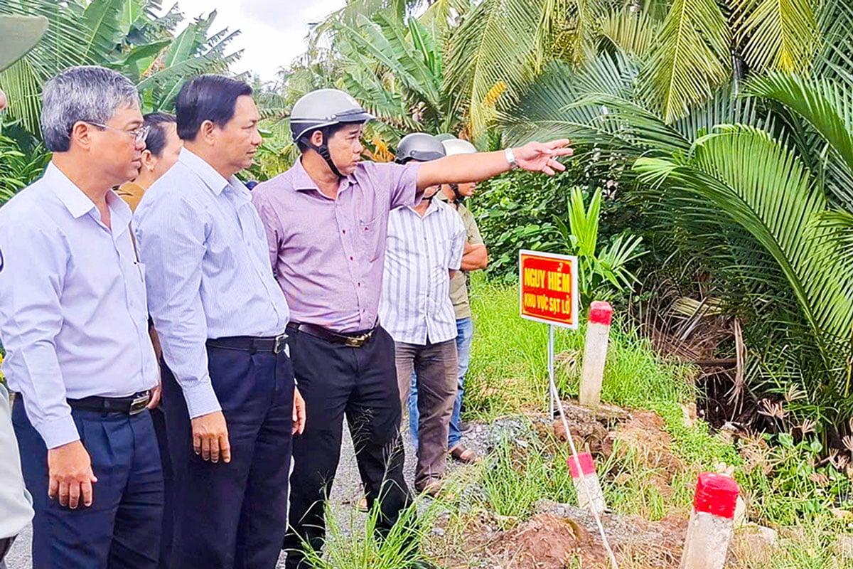 Setiausaha Parti Wilayah Tran Van Lau (dua dari kiri) memeriksa tapak tanah runtuh di dusun Vam Dinh, komune Phong Thanh.