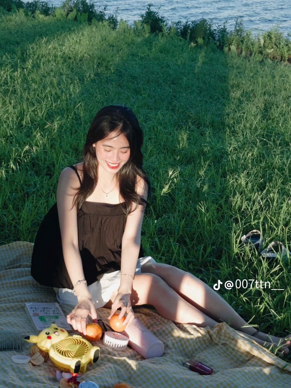 Oamenii și turiștii se relaxează sub copacii din parcul Le Loi.