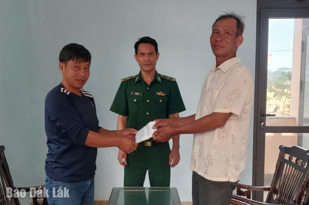 បន្ទាប់ពីត្រូវបានសម្របសម្រួលដោយប៉ុស្តិ៍ឆ្មាំព្រំដែន Hoa Hiep Nam លោក Dao Kim Tri (ស្តាំ) បានគាំទ្រលោក Le Van Cuong ចំនួន ៩លានដុង ដើម្បីទូទាត់សងការខូចខាត។