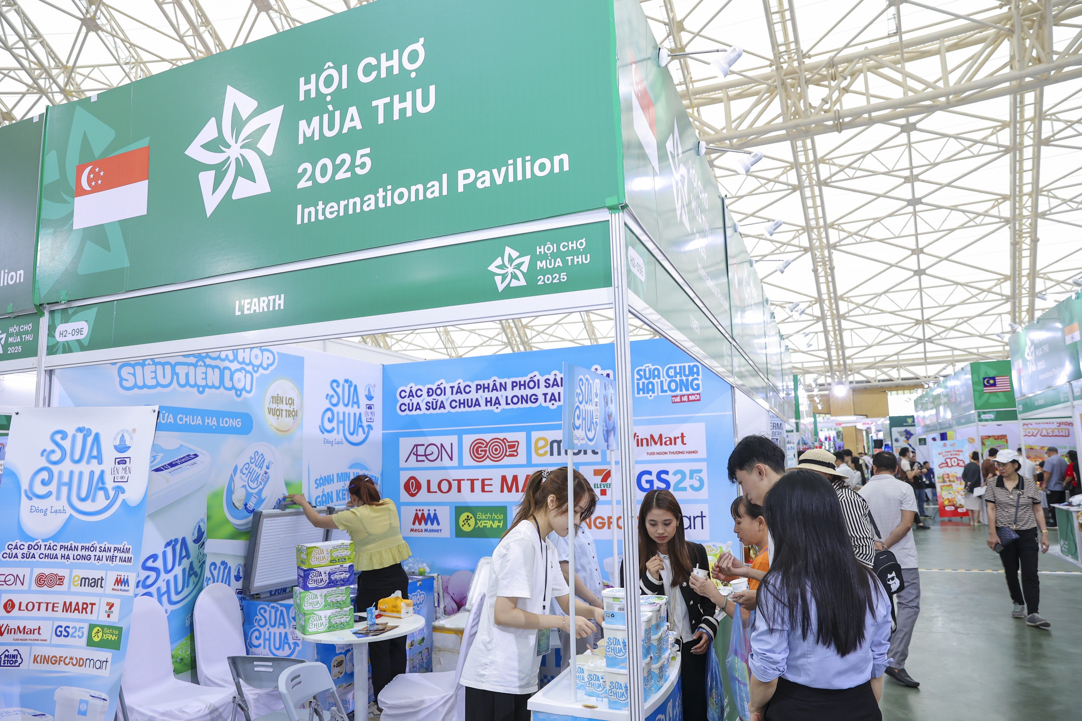 Návštěvníci se zastavili u singapurského stánku, aby ochutnali jogurtové výrobky. Personál stánku provázel zákazníky a obsluhoval je přímo u pultu.