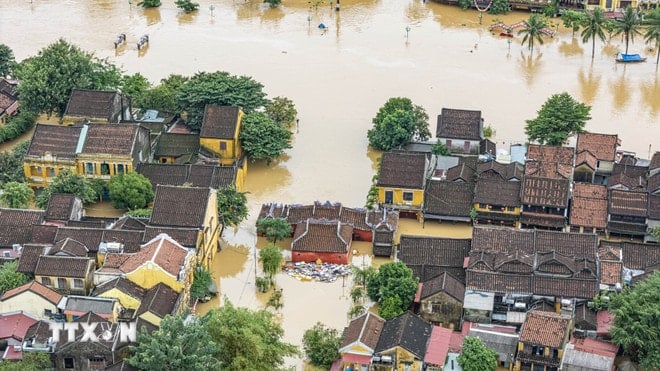 ការកើនឡើងកម្រិតទឹកនៅក្នុងទន្លេ Hoai បានលិចលង់ផ្ទះបុរាណរាប់ពាន់ខ្នងនៅ Hoi An ។ (រូបថត៖ Anh Dung/VNA) ttxvn-pho-co-hoi-an-da-nang-bi-ngap-sau-trong-mua-lu-lich-su-8375119-2.jpg