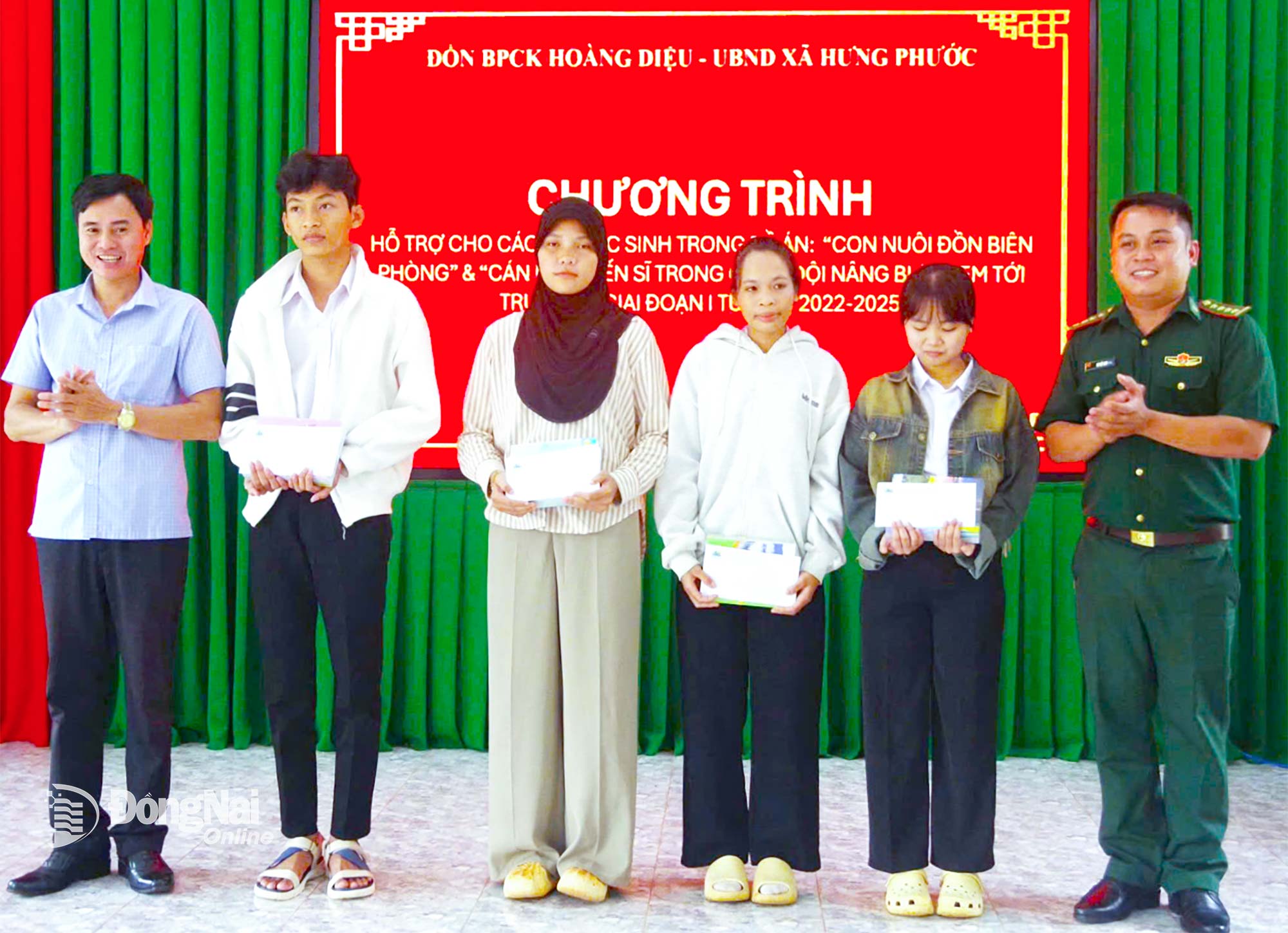 Đại diện Đồn Biên phòng cửa khẩu Hoàng Diệu (bìa phải) và chính quyền xã Hưng Phước trao học bổng cho học sinh có hoàn cảnh khó khăn. Ảnh: C.T.V