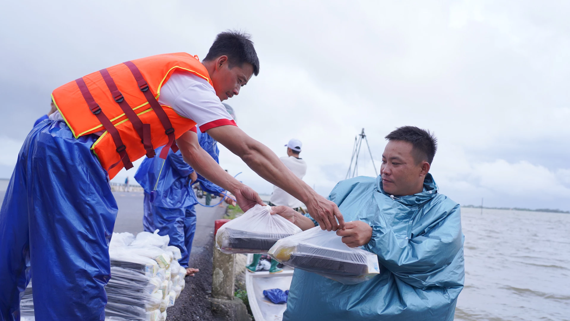 Nguyen Van Chuyen (kulit kanan) gembira menerima sokongan beras pada hari-hari keluarganya terpencil akibat banjir - Foto: L.T