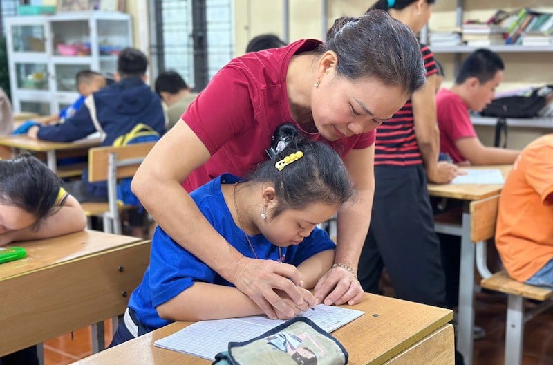 Fru Le Thi Hoa vägleder eleverna i skrivande.