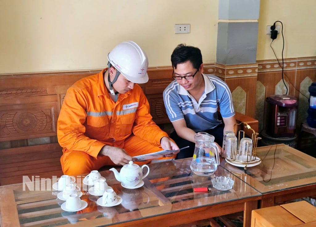 Tjänstemän i Ly Nhan Regional Electricity Management Team uppmanar kunderna att betala elräkningar utan kontanter.