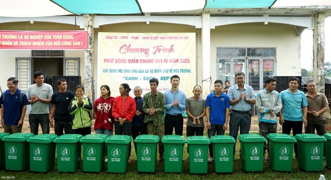 Leiders van de wijk Cu Bao schonken plastic afvalbakken aan huishoudens.