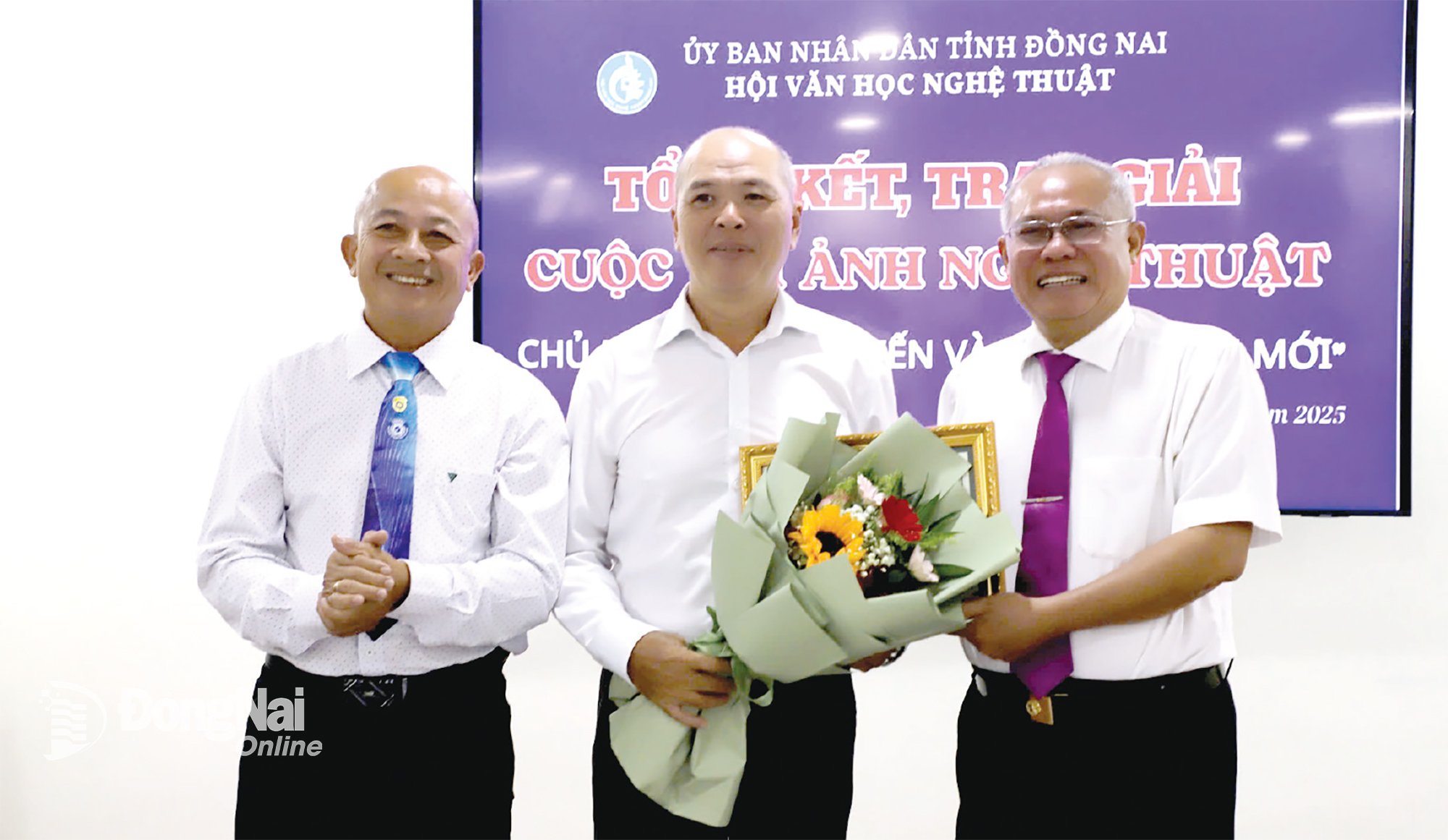 Phó Chủ tịch Thường trực Hội Văn học nghệ thuật Đồng Nai Phạm Văn Hoàng (bìa phải) tặng hoa cho nghệ sĩ nhiếp ảnh Nguyễn Văn Thương. Ảnh: Cẩm Thành