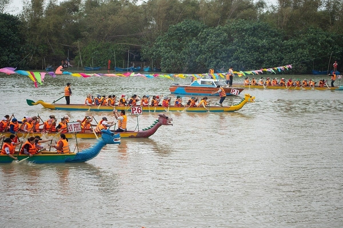 দা রাং নদীর তীরে নৌকা বাইচ উৎসবে নৌকা দলগুলি উৎসাহের সাথে প্রতিযোগিতা করছে।