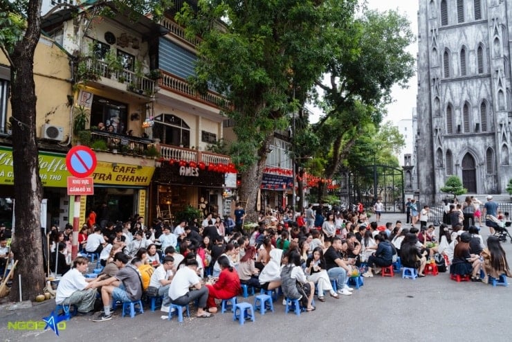 Ungdomar tar foton framför den antika utsikten över Hanois katedral.