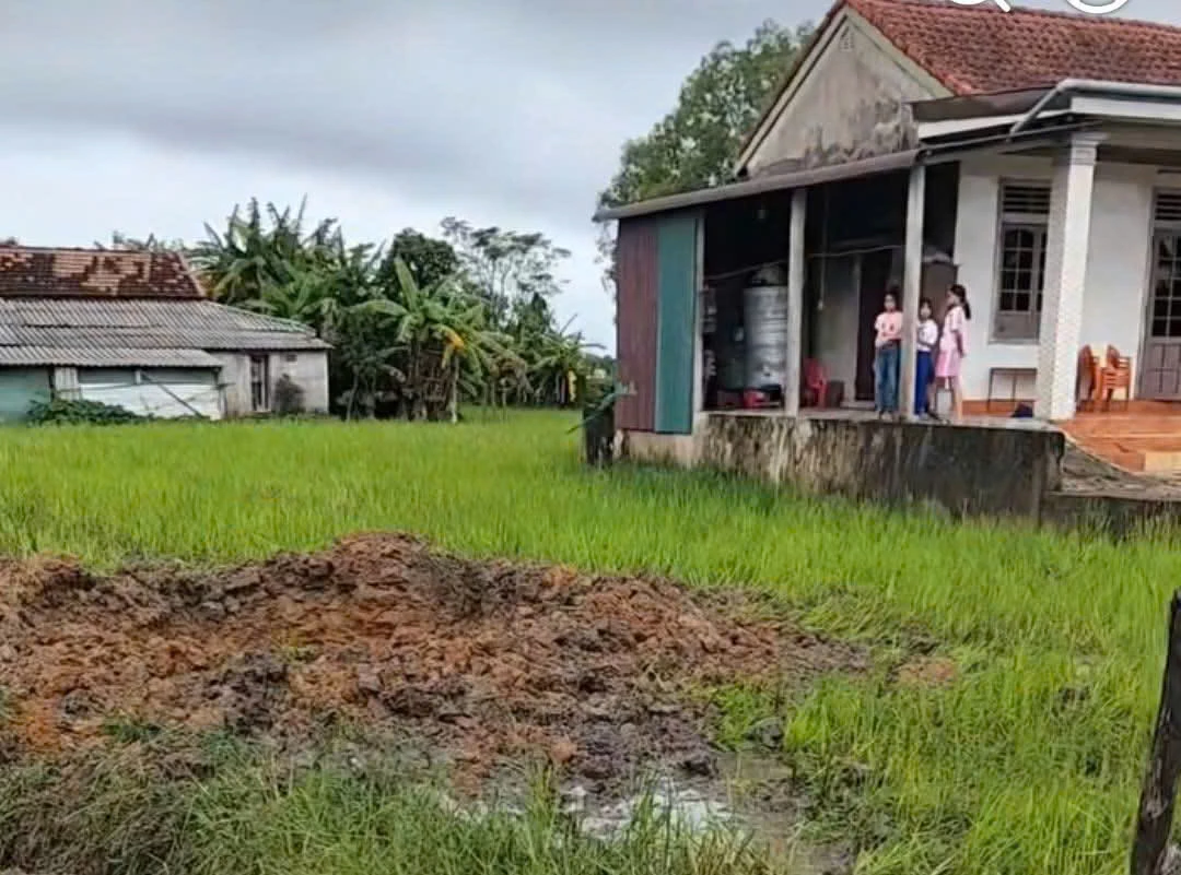 Hố sâu xuất hiện trên ruộng lúa gần nhà dân ở thôn Lệ Xuyên, xã Nam Cửa Việt nghi do bom đạn phát nổ - Ảnh: Cắt từ clip