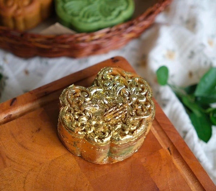 After baking, the mooncakes are cooled and covered with a layer of 24K gold leaf. (Photo: NVCC).