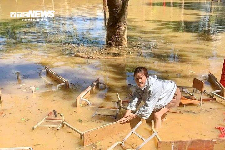 គ្រូបង្រៀន​បាន​ទាញយក​ប្រយោជន៍​ពី​ទឹក​ជំនន់​ដើម្បី​សម្អាត​តុ និង​កៅអី​ដែល​មាន​ភក់។