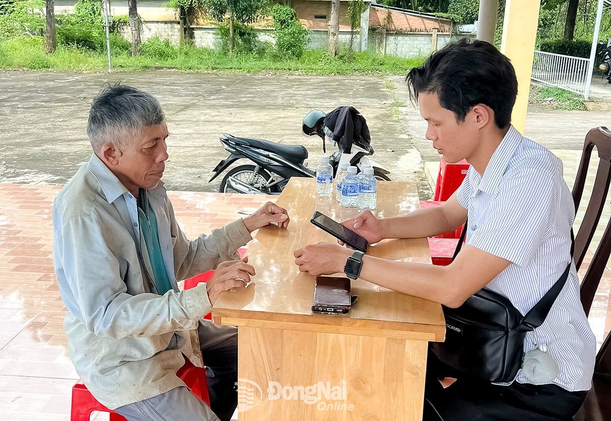 Folk får hjelp til å installere digitale signaturer ved det offentlige administrasjonssenteret i Dong Tam kommune, Dong Nai-provinsen. Foto: C.T.V.