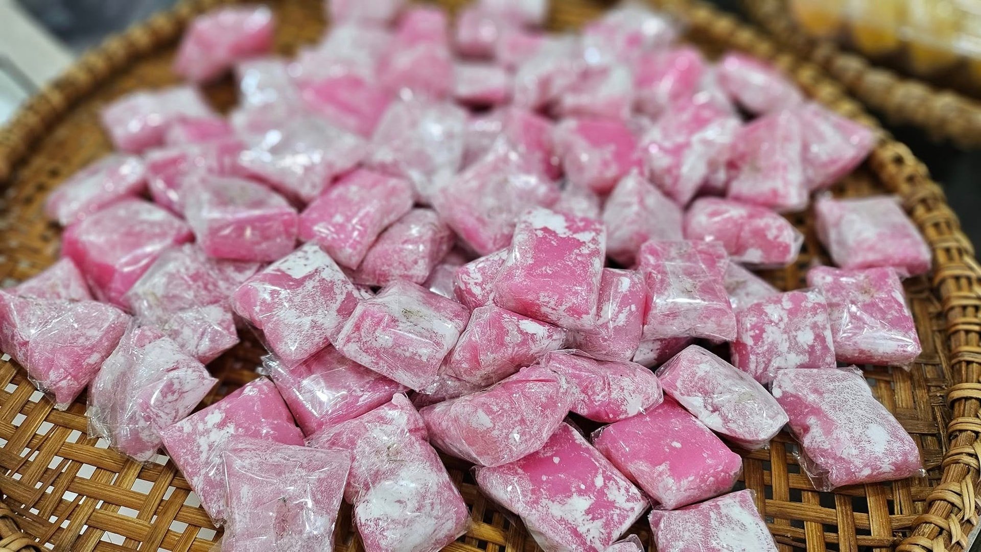 يتم تقطيع الكعكة الوردية إلى قطع صغيرة الحجم.