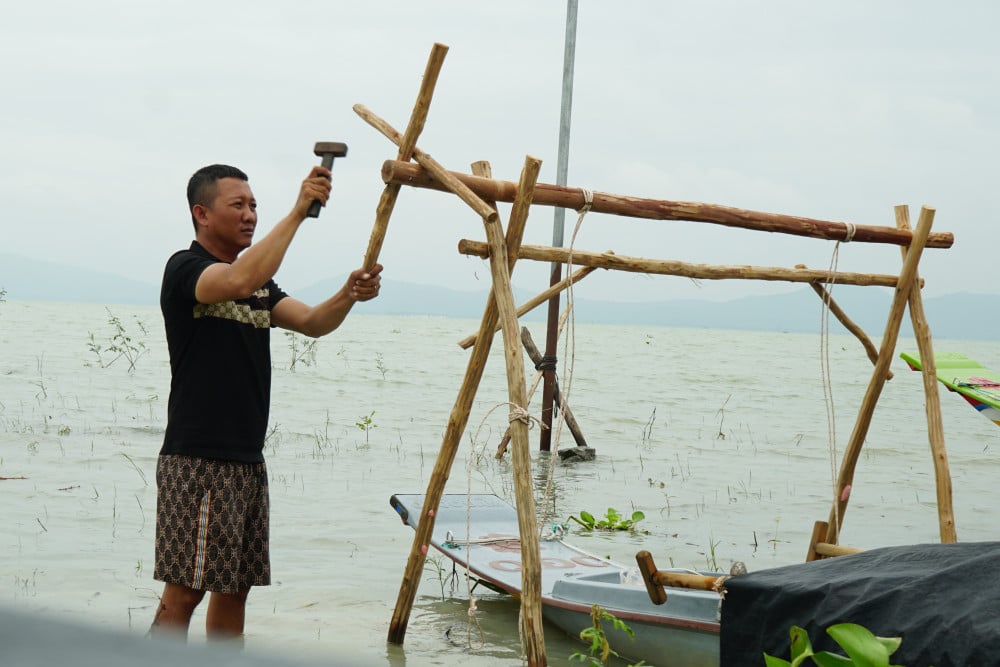 Người dân địa phương làm dàn giáo, đưa vỏ lãi lên khỏi mặt nước, nhằm tránh sự tác động của mưa gió