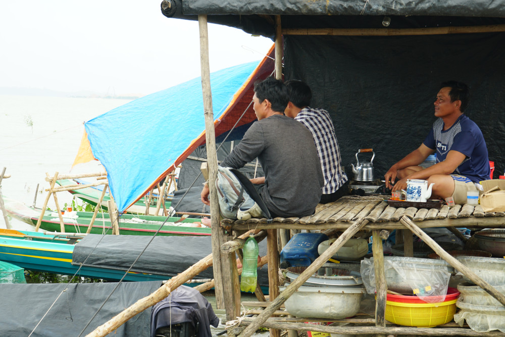 Một nhóm ngư dân thất nghiệp, ngồi uống trà cầu mong mưa bão mau qua để trở lại với nghề giăng câu thả lưới