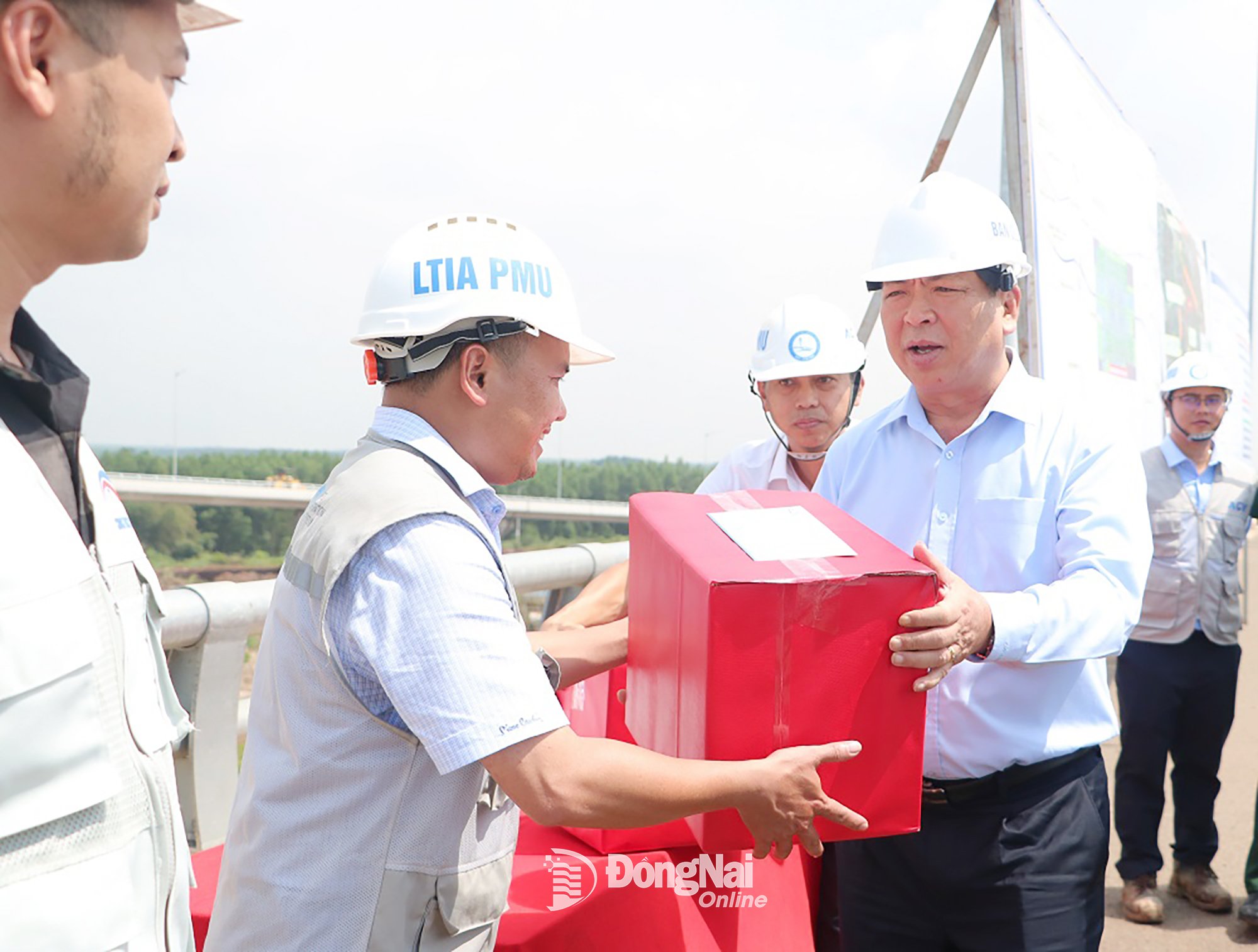 A párt központi bizottságának tagja, Tran Hong Minh építésügyi miniszter ajándékokat ad át a Long Thanh repülőtér projekt építőmunkájának ösztönzésére. Fotó: Pham Tung